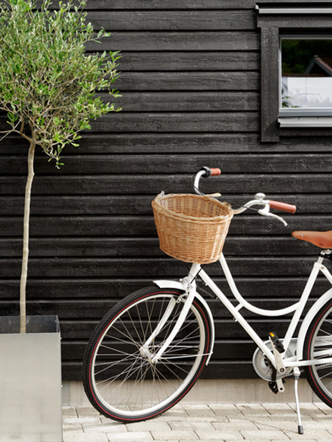 Måleri Mauleriet Hus med svartmålad fasad och vit cykel